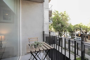 Enjoy a peaceful morning coffee on your private balcony with street views and lush greenery.