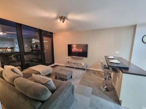 A stylish, open-concept living area with comfortable seating, ready to host your next movie night or game evening