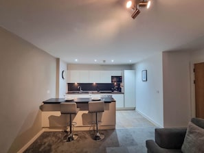 This modern kitchen features a beautiful breakfast island, ideal for prepping meals, enjoying breakfast, or sipping your favorite drink.