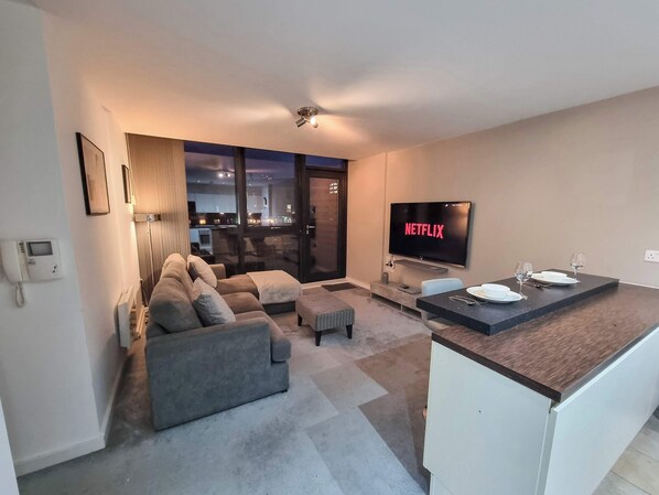 Relax and unwind in this cozy, light-filled living room, perfect for evenings spent lounging with family or friends