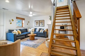 Living area and stairwell leading to Bedroom 1