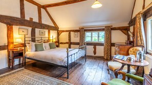 Bedroom one showcases wooden beams and elm flooring