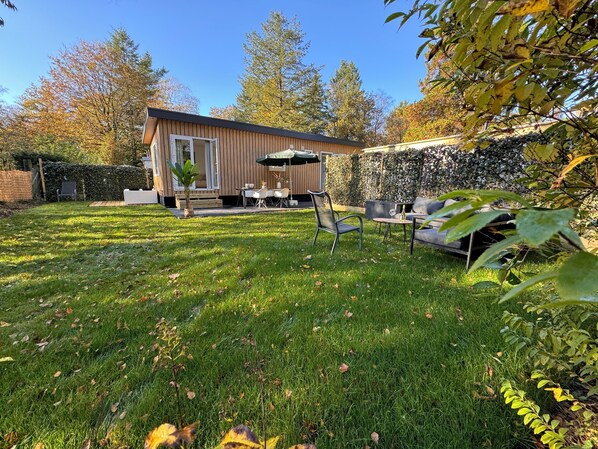 Big garden with loungeset facing the woods on the left.