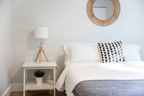You feel enveloped in comfort as you relax on the queen bed, surrounded by a room designed for tranquility.