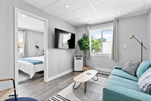 The living room’s plush seating beckons you to sink in and relax, surrounded by light and airy decor.