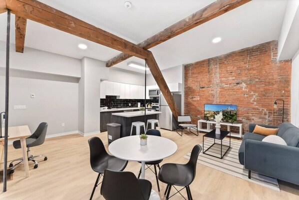 Spacious open-concept living and dining area featuring a vibrant sofa, modern furnishings, and a stylish entertainment setup—ideal for gatherings and relaxation.