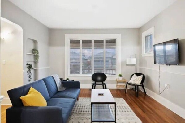 The living room’s plush seating beckons you to sink in and relax, surrounded by light and airy decor.