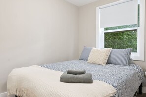 The bedroom’s serene ambiance invites you to relax, with a plush bed that promises a restful night's sleep.