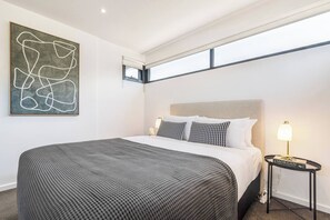  The primary bedroom comes with a plush queen-sized bed, set with side tables and reading lights.
