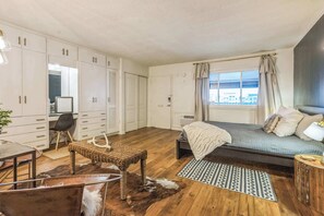 A cozy and stylish studio featuring built-in storage and warm, inviting decor