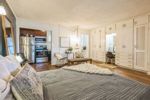 Studio with queen bed, Smart TV, sitting area, and workstation