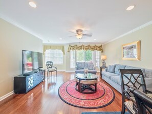 Bright and airy living space featuring a large flat-screen TV and ample natural light for a warm, inviting ambiance.
