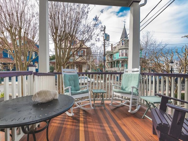 Unwind on the private front porch with comfortable seating, offering a front-row view of historic Jackson Street.