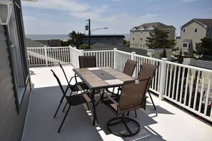 Spacious deck with outdoor seating and stunning views, ideal for enjoying al fresco dining or morning coffee.