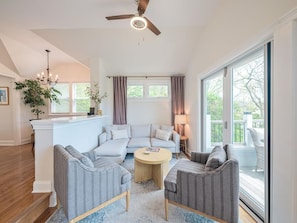 Cozy living room with modern furnishings and sliding doors leading to the deck for seamless indoor-outdoor living.