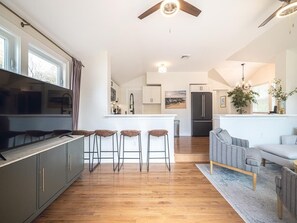 Stylish living room featuring a flat-screen TV, hardwood floors, and an airy layout.
