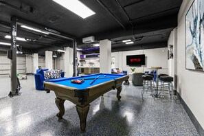 Enjoy endless entertainment in the game room, featuring a pool table, a cozy lounging area, and a smart TV for all your favorite shows or games. Perfect for a fun-filled gathering or a relaxing night in!