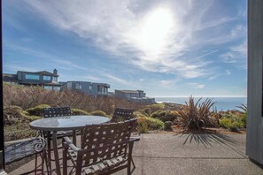 Step out from the downstairs bedroom onto a private patio with seating and sweeping views of the ocean.