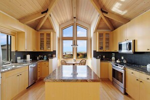 Prepare meals with ease in this thoughtfully designed kitchen, complete with a breakfast nook overlooking the sea.