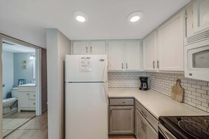The fully equipped kitchen features quartz countertops and subway tile backsplash and has everything you need to prepare meals for family & friends.