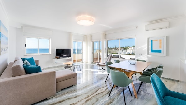 Bright, stylish living room with ocean-facing windows and open-plan comfort. #CoastalCharm #VacationVibes