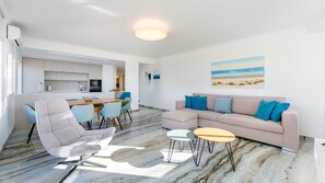 Bright, stylish living room with ocean-facing windows and open-plan comfort. #CoastalCharm #VacationVibes