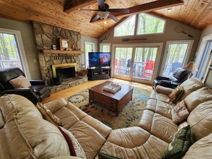 Spacious living room with wood burning fireplace and big screen TV