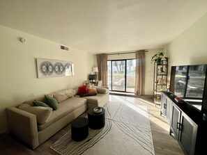Spacious living room with view of courtyard. Working space with monitor
