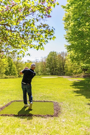 Enjoy your own backyard golf hole with putting green, tee box, and clubs!