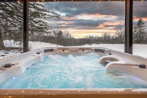 7-person jacuzzi with dual jets and ambient lighting, stunning sunset views.