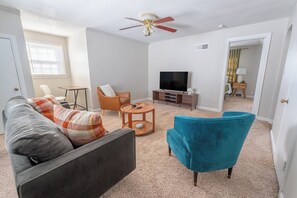 Cozy living room with comfy couch, smart TV, and desk & chair
