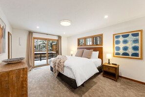 Master bedroom with king bed and sliding door leading to back deck with hot-tub.