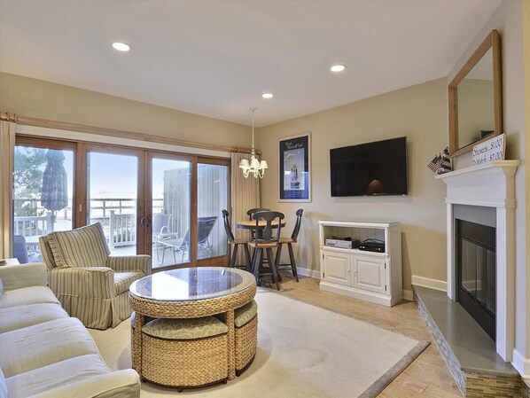 Cozy living room with a raised hearth fireplace and comfortable seating, perfect for relaxation after a beach day.