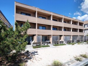 Back view of the property, showcasing balconies and the proximity to the sandy dunes and beach access.