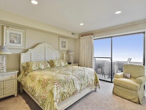 Bright and airy oceanfront master suite featuring a comfortable bed and large windows with breathtaking views.
