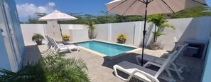 Modern poolside patio with comfortable lounge chairs.