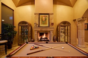 Cozy up in this additional living area boasting a warming fireplace and a pool table for a friendly challenge.