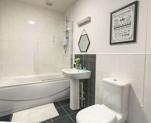 Step into luxury in this sleek, fully-equipped bathroom with bathtub. 