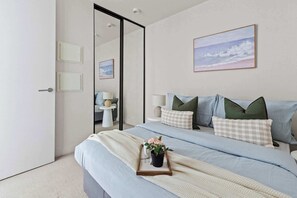 The master bedroom with a double sized bed & plush pillows.