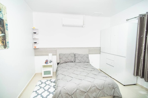 Cozy bedroom featuring a plush bed, modern furnishings, and soft lighting for a comfortable and inviting atmosphere."