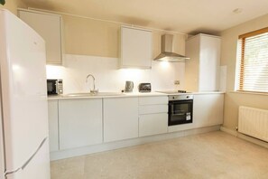 New modern kitchen with all you need to cook - pots / pans / coffee plunger . 