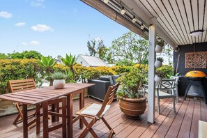 A private retreat surrounded by greenery, featuring a lounge area and BBQ.