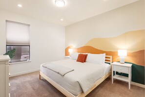 This bedroom offers a simple design with a queen-sized bed,  cabinet and bedside table for your convenience. The room's warm ambience creates a relaxing and inviting atmosphere, perfect for unwinding after a day of adventure