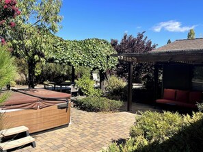 Outdoor patio in back with hot tub and bocce court 