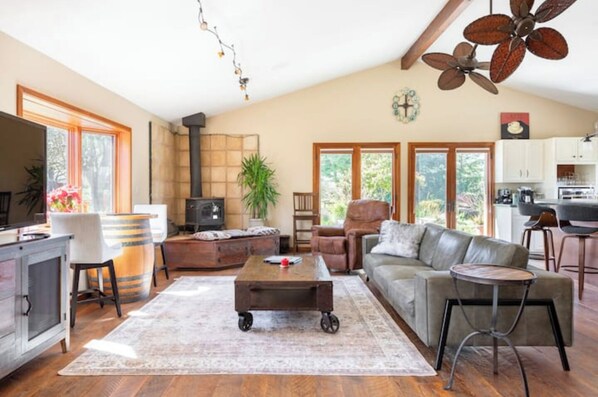 Large, open living room with lots of seating, fireplace and 65" TV.