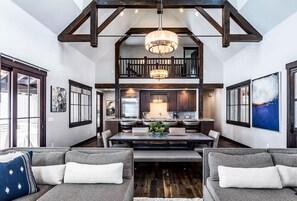 Stunning wood beams and expansive windows bring mountain charm and natural light to this spacious living area