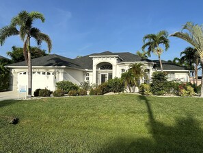 Tropical curb appeal meets timeless elegance in this stunning Cape Coral escape