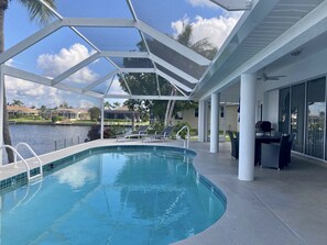 Unwind beneath the lanai, just steps from the heated pool and tranquil waters