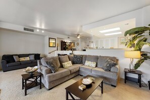 Unwind in this cozy seating area with stylish decor, large couches, and a welcoming ambiance for your tropical retreat.