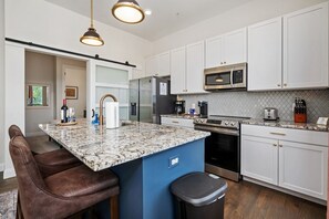 The kitchen island features tons of counter space for cooking, working, or relaxing with cozy new Arhaus stools! 